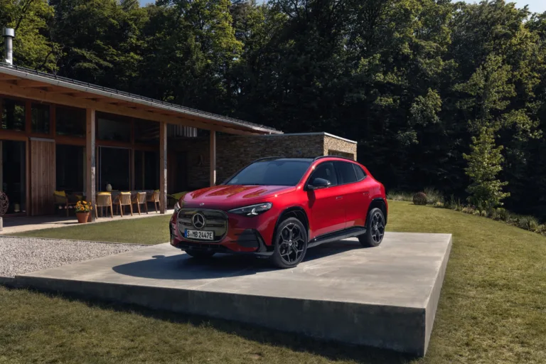 Rød elektrisk Mercedes-Benz GLA parkeret foran et moderne træhus