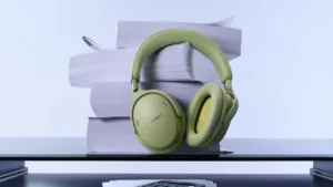 Grønne Bose QuietComfort-hovedtelefoner ved bøger på et bord