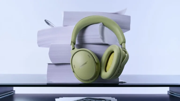 Grønne Bose QuietComfort-hovedtelefoner ved bøger på et bord