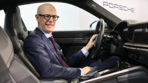 Porsches administrerende direktør Michael Leiters i en Porsche