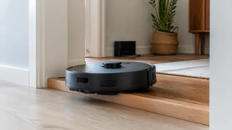 Robotstøvsuger på vej over et højt dørtrin i en bolig